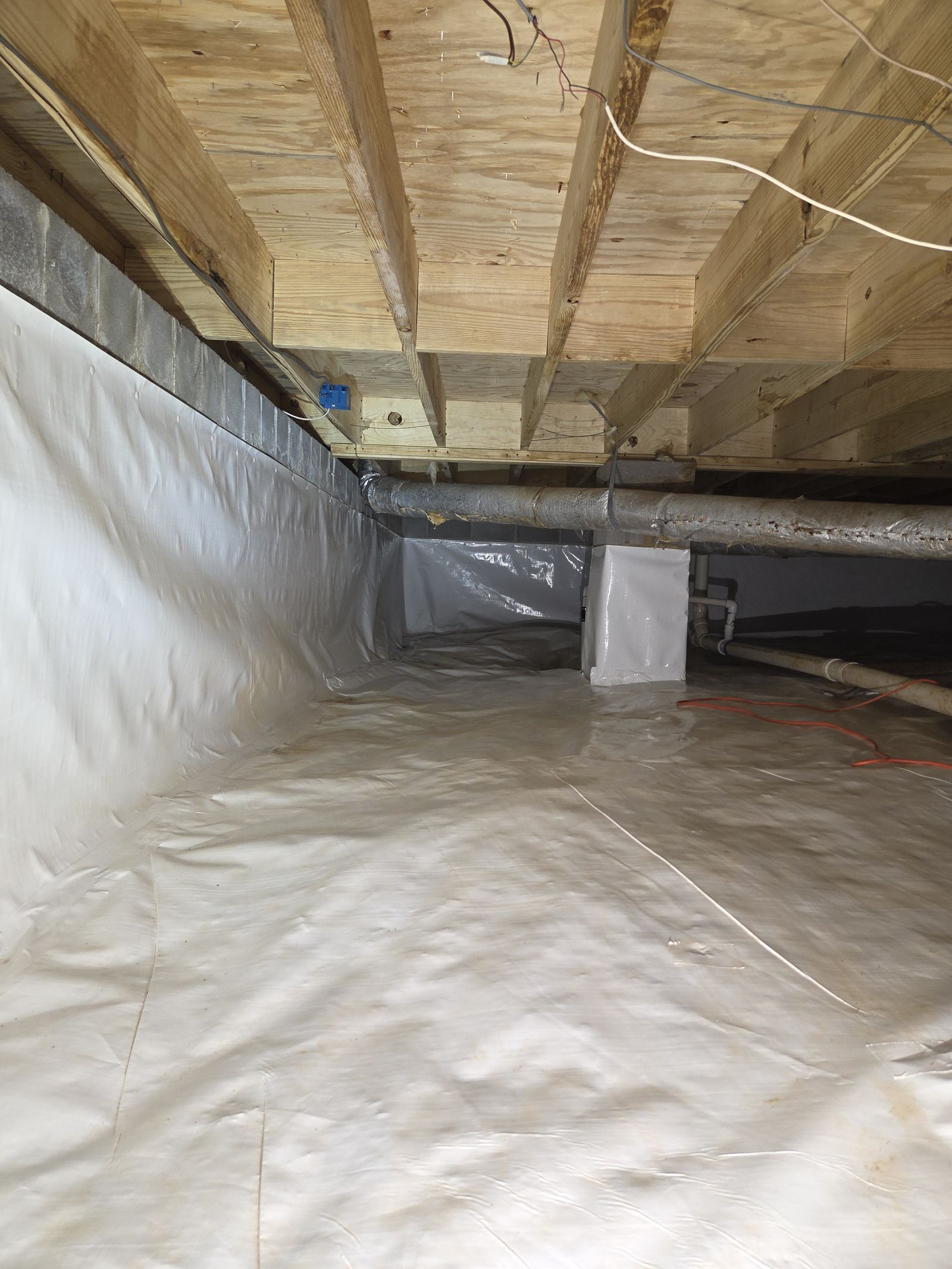 Finished crawlspace encapsulation in Chattanooga, TN with a clean white vapor barrier running up the foundation wall and a sealed sump lid